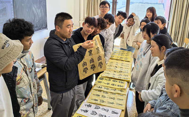 徐润刚用手语为学生们讲解书法篆刻。beat365英国官方网站供图